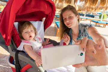 Mother taking selfie with baby girl on resort