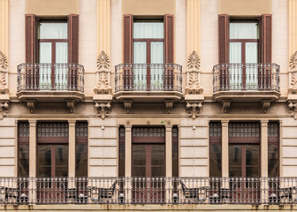 Windows and balconies in row on facade of historic building