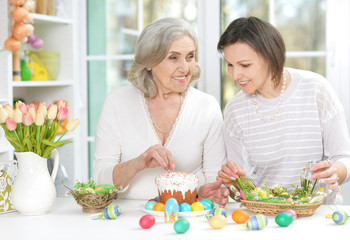 Portrait of mother and daughter colouring eggs