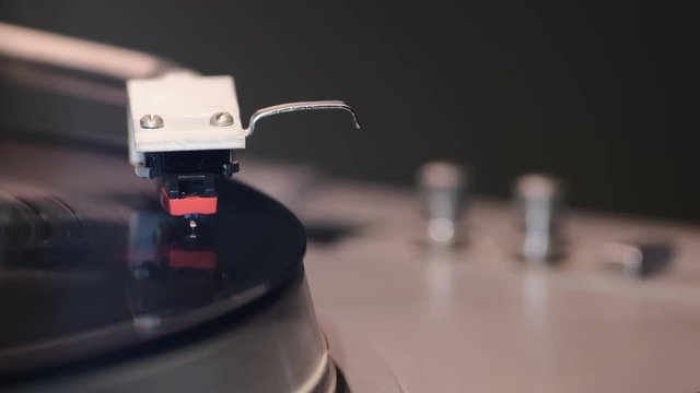 middle distance footage of vintage playing turntable with focus on stylus