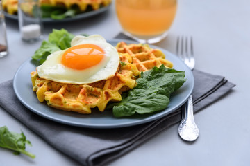 Spinach cheese waffles with fried egg on gray wooden background. Selective focus.