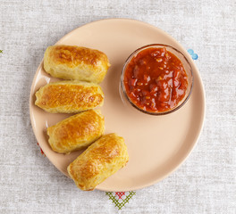 Pastries and sauce on a plate on a napkin.