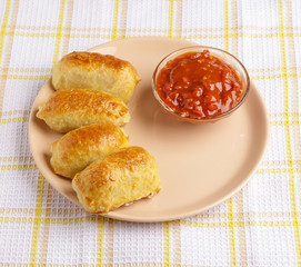 Pastries and sauce on a plate on a napkin.