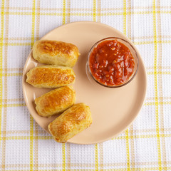 Pastries and sauce on a plate on a napkin.