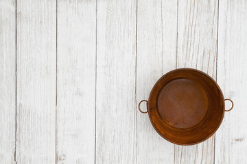 Rusted tin pail on weathered whitewash textured wood background