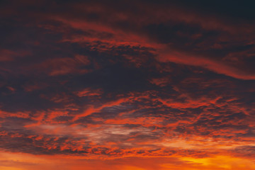 Fiery red blood vampire dawn. Amazing warm dramatic fire cloudy sky. Vivid orange sunlight. Atmospheric background of sunrise in overcast weather. Hard cloudiness. Storm clouds warning. Copy space.