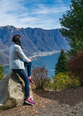 Naklejka premium Young girl enjoying lake view on peak of mountain. Tourist traveler background valley landscape view mockup.