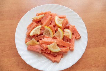 Slices of salted salmon with lemon. 	Slices of salted salmon with lemon for sushi rolls