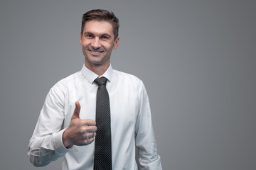 Confident businessman gesturing thumb up