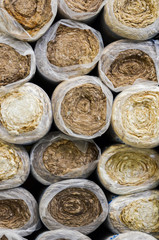 Close up  front view of round basalt mineral wool packages  in plastic foil .
