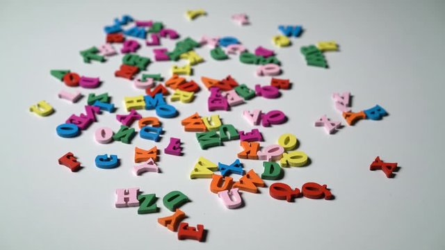 Alphabet letters on wooden scrabble pieces scattered