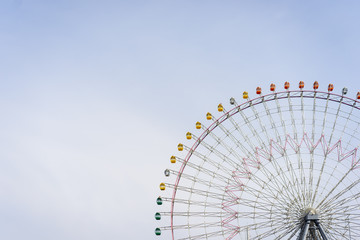 Playground giant festival funfair ferris wheel against blue sky,