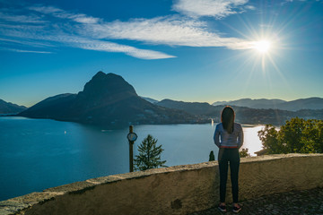 Fototapeta na wymiar Young girl enjoying view on lake Lugano and mountain San Salvatore, Switzerland, Europe, Ticino