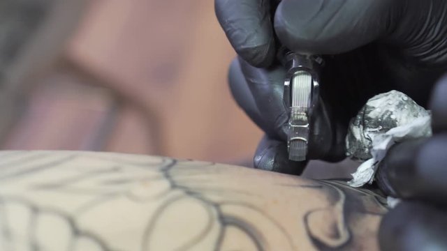 Master tattoo artist at work, close-up. Tattoo Studio.