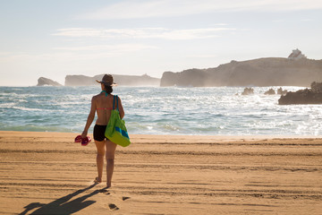 woman walking on the sand of a beautiful beach