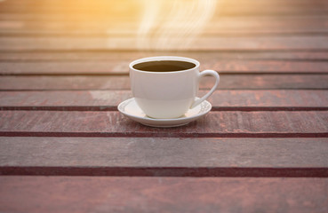 White cup of coffee on wooden background for coffee drink concept