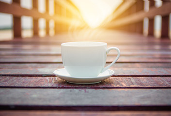 White cup of coffee on wooden background for coffee drink concept