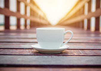 White cup of coffee on wooden background for coffee drink concept