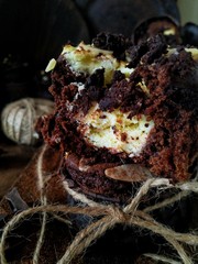 Half of a chocolate muffin with curd filling on a dark background close-up on the side view