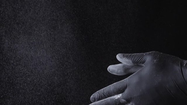 Close-up of a chef wiping flour from hands. Frame. Slow motion particles of dust. Clap chef. Chef clapping hands covered in flour. End of a work day concept