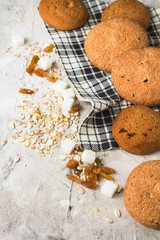 Oatmeal cookies on linen napkin and stone background. Oatmeal, raisins, sugar cubes. Scene from breakfast