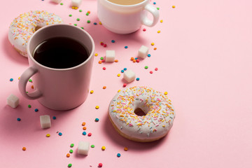 Cups with coffee or tea, Fresh tasty sweet donuts on a pink background. Fast food concept, bakery, breakfast, sweets, coffee shop. Flat lay, top view, copy space.