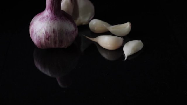 Excellent side view close up of fresh young head of garlic. Frame. Close-up of garlic on black background