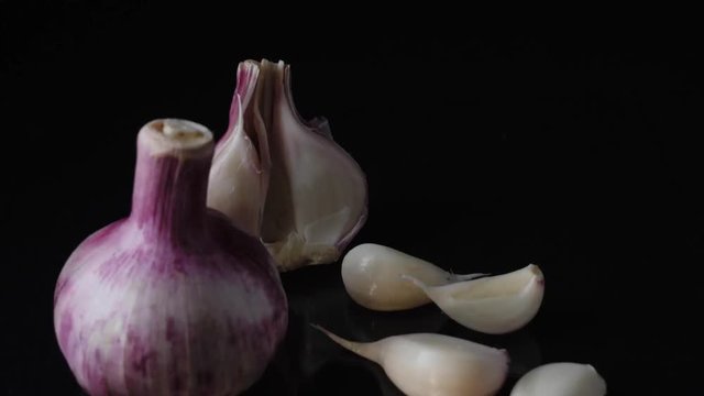 Excellent side view close up of fresh young head of garlic. Frame. Close-up of garlic on black background