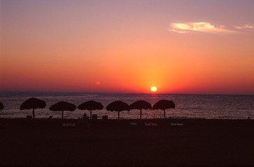 Puerto Escondido, Mexico, circa january 1998: Sun setting over the ocean with moon already in the...