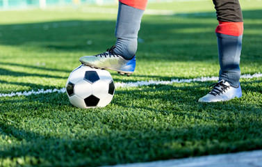 Boy puts his leg on ball on soccer field.  Training, active lifestyle, sport, children activity concept 
