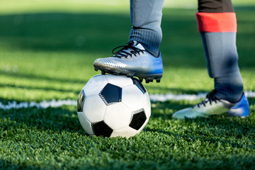 Boy puts his leg on ball on soccer field.  Training, active lifestyle, sport, children activity concept 