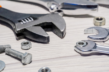 adjustable and ordinary wrenches, nuts and bolts on the table