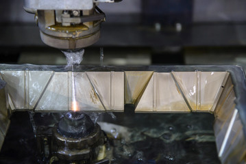 The wire EDM machine cutting  the mould parts  lubricant fluid. The modern mould manufacturing process.