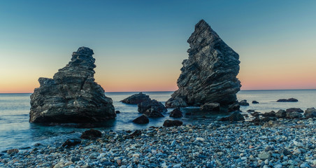 Nerja, Malaga, Andalusi, Spain - February 4, 2019: Playa del Molino, small stone beach with two large rocks on the shore, Nerja, southern Spain