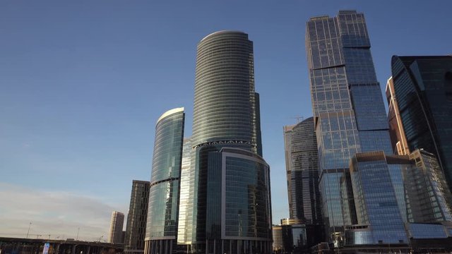 Panoramic view of the financial district in the downtown of Moscow. Cityscape and famous skyscrapers of the city. Daytime. Camera movement from left to right. Daytime, bright blue sky. Sunny weather