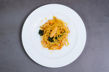 Spaghetti with sausage, Stir-fried sausage, Italian food.Spaghetti with red sauce, white plate on the table in the morning restaurant.