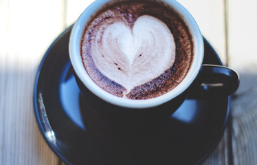 Coffee cup on the table in the cafe.In a cafe with a cup of coffee.Do not focus on objects.