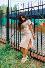 Portrait of a swag girl standing next to the iron fence