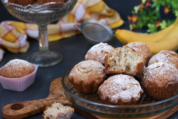 Muffins with bananas are located on plates against a dark background