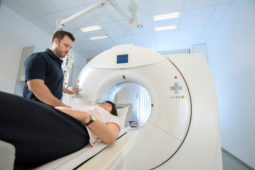 Patientin auf Untersuchungstisch, MTRA betreut Untersuchung im Computertomographen