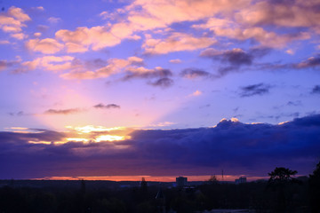 Bright sunrise in colorful nimbostratus. Rays of the sun coming out of the clouds