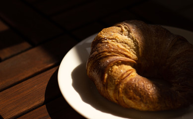 A fall breakfast with coffee, capuccino and a big french croissant
