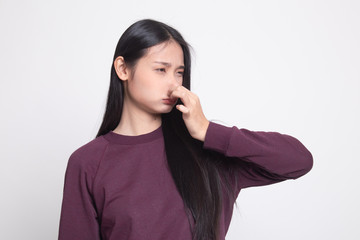 Young Asian woman  holding her nose because of a bad smell.
