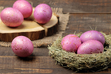 Easter. Pink easter eggs in a nest on a brown wooden table. Happy easter. holidays