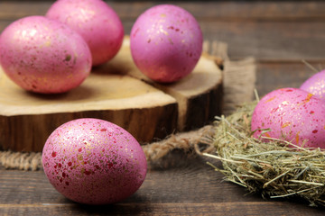 Easter. Pink easter eggs in a nest on a brown wooden table. Happy easter. holidays
