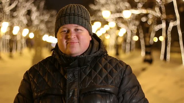 Portrait of happy man dancing outdoors during cold winter evening