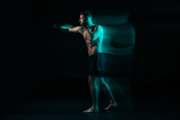 Fototapeta na wymiar long exposure of green light and shirtless muscular mma fighter doing punch