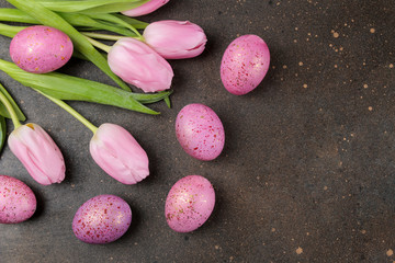 Obraz na płótnie Canvas Easter. Pink Easter eggs and flowers tulips on a dark background. Happy easter. holidays. top view.