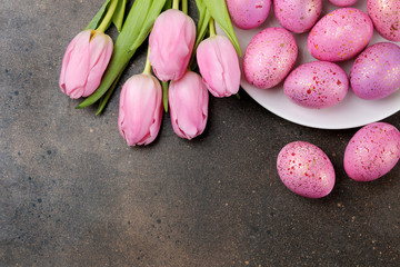 Easter. Pink Easter eggs and flowers tulips on a dark background. Happy easter. holidays.