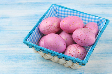 Easter. Pink easter eggs in a basket on a blue wooden table. Happy easter. holidays.